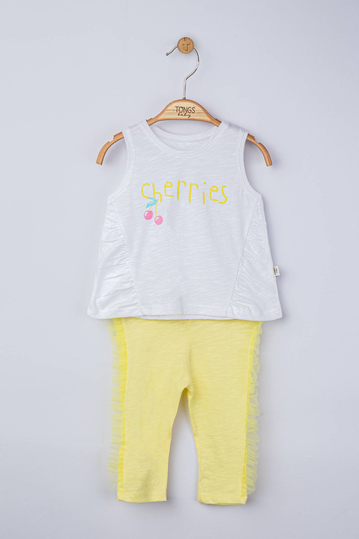 white sleevelees shirt with print and yellow pants